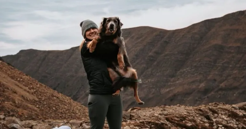 Melissa, reactive dog groomer at PAWS Dog Daycare Calgary, with her dog in the mountains